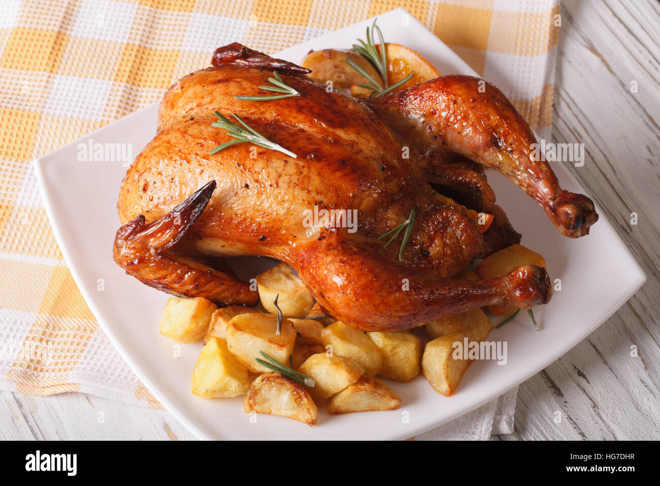 whole roast chicken with oranges and potatoes on a plate. horizontal Stock Photo