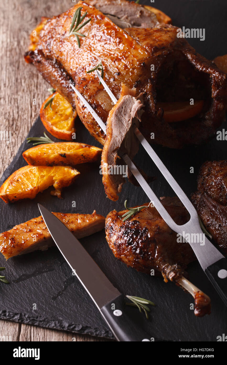 Cutting the roast duck close up on a black slate board. vertical Stock