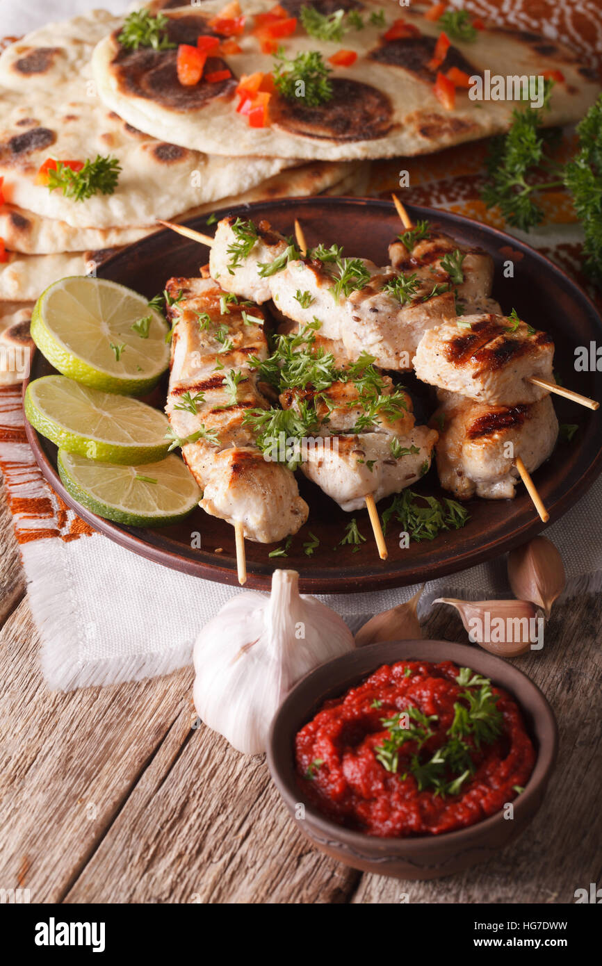 Delicious chicken tikka on skewers closeup and chutney. vertical Stock Photo