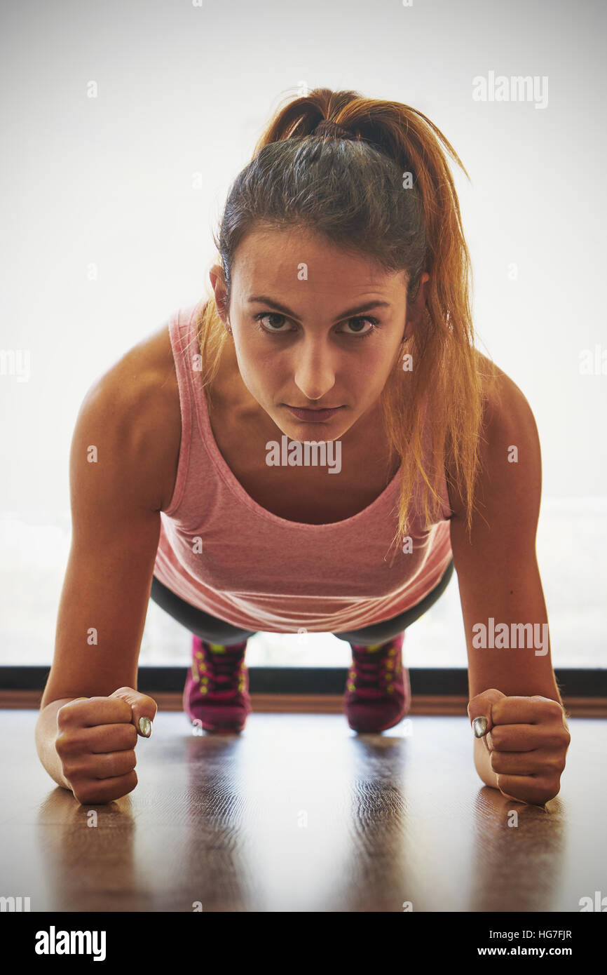 Fit young woman doing pushups in a gym Stock Photo - Alamy