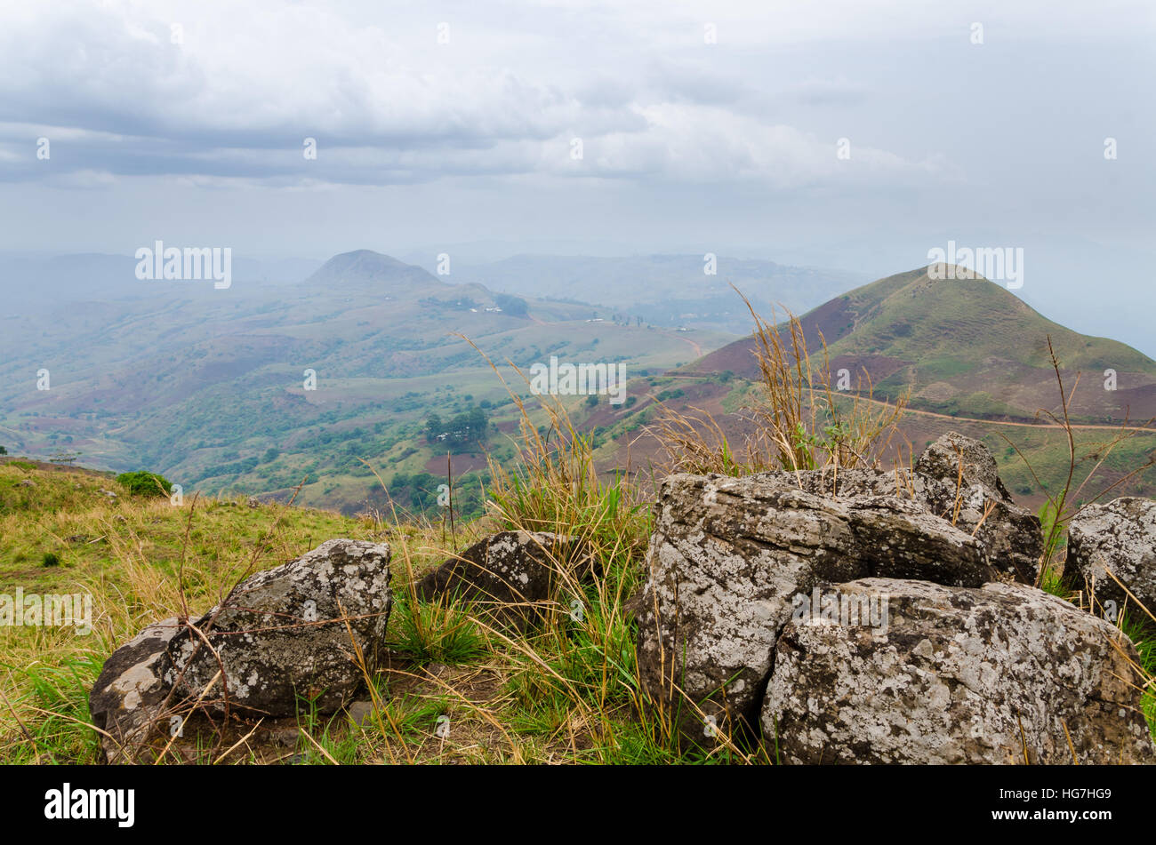 The Ring Road in Cameroon, Africa with soft hills in background and large rocks in foreground on overcast day Stock Photo