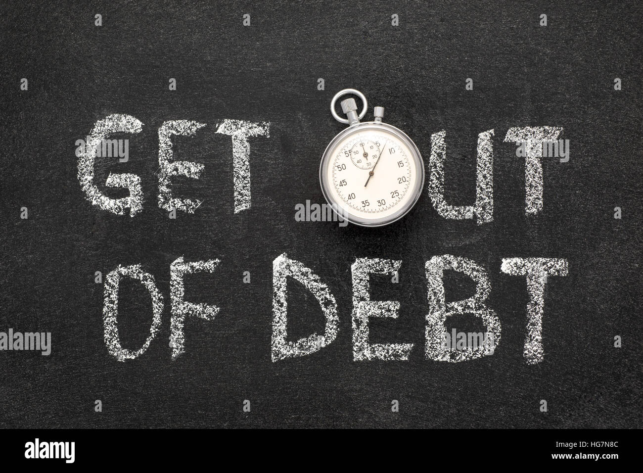 get out of debt phrase handwritten on chalkboard with vintage precise stopwatch used instead of O Stock Photo