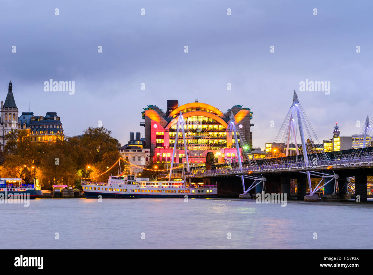 Evening Hungerford Bridge and Golden Jubilee Bridge London looking towards Charing Cross Station and Embankment Place Stock Photo