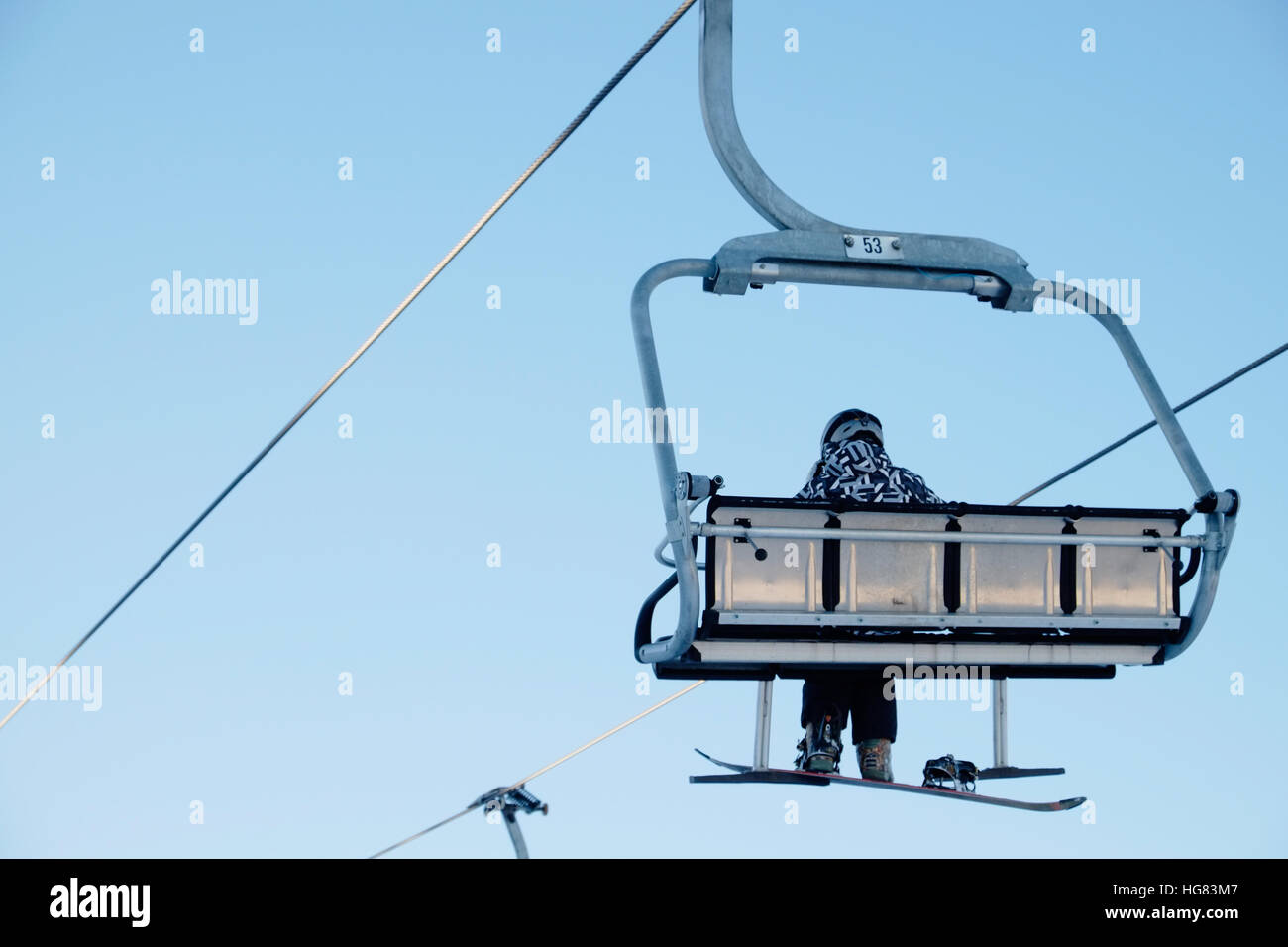 Snowboarder sitting on the chairlift Stock Photo