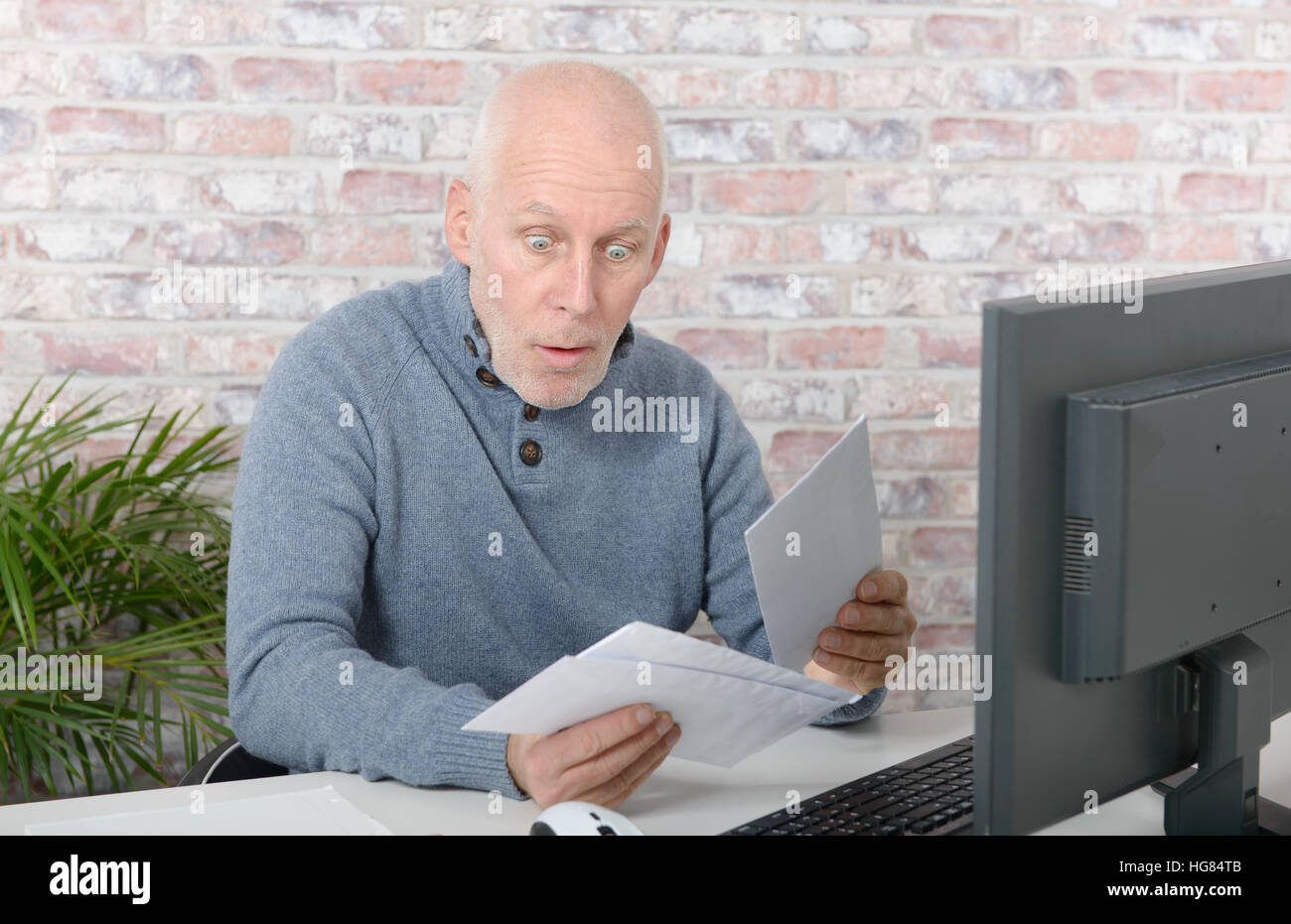 mature businessman opening letter envelope, with astonishment Stock Photo
