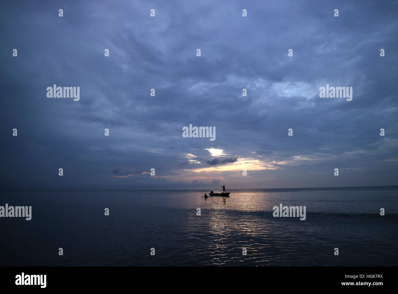 Silhouette friends enjoying in sea against cloudy sky Stock Photo