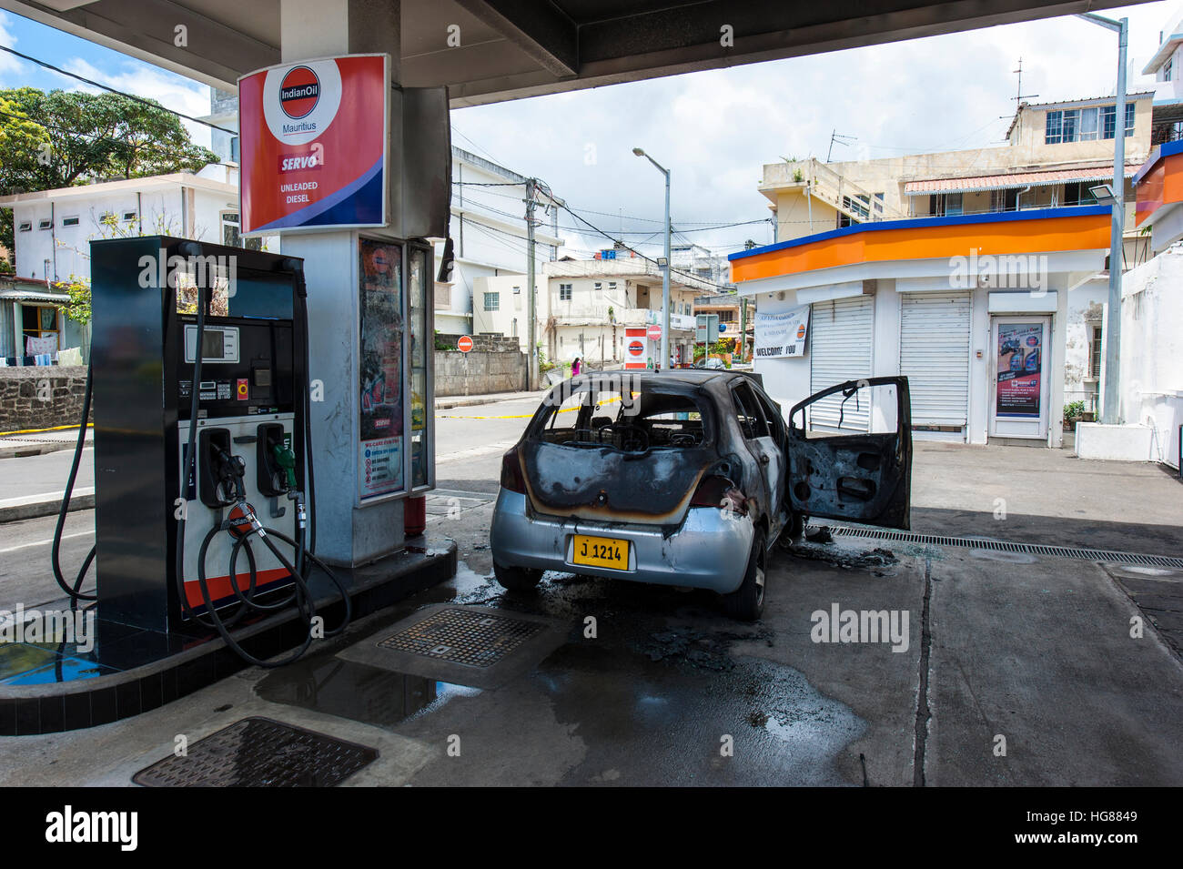A gas station in Mahebourg town, Mauritius Island. A burnt car next to