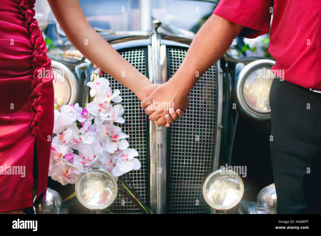 bride and groom in front of a retro car Stock Photo - Alamy