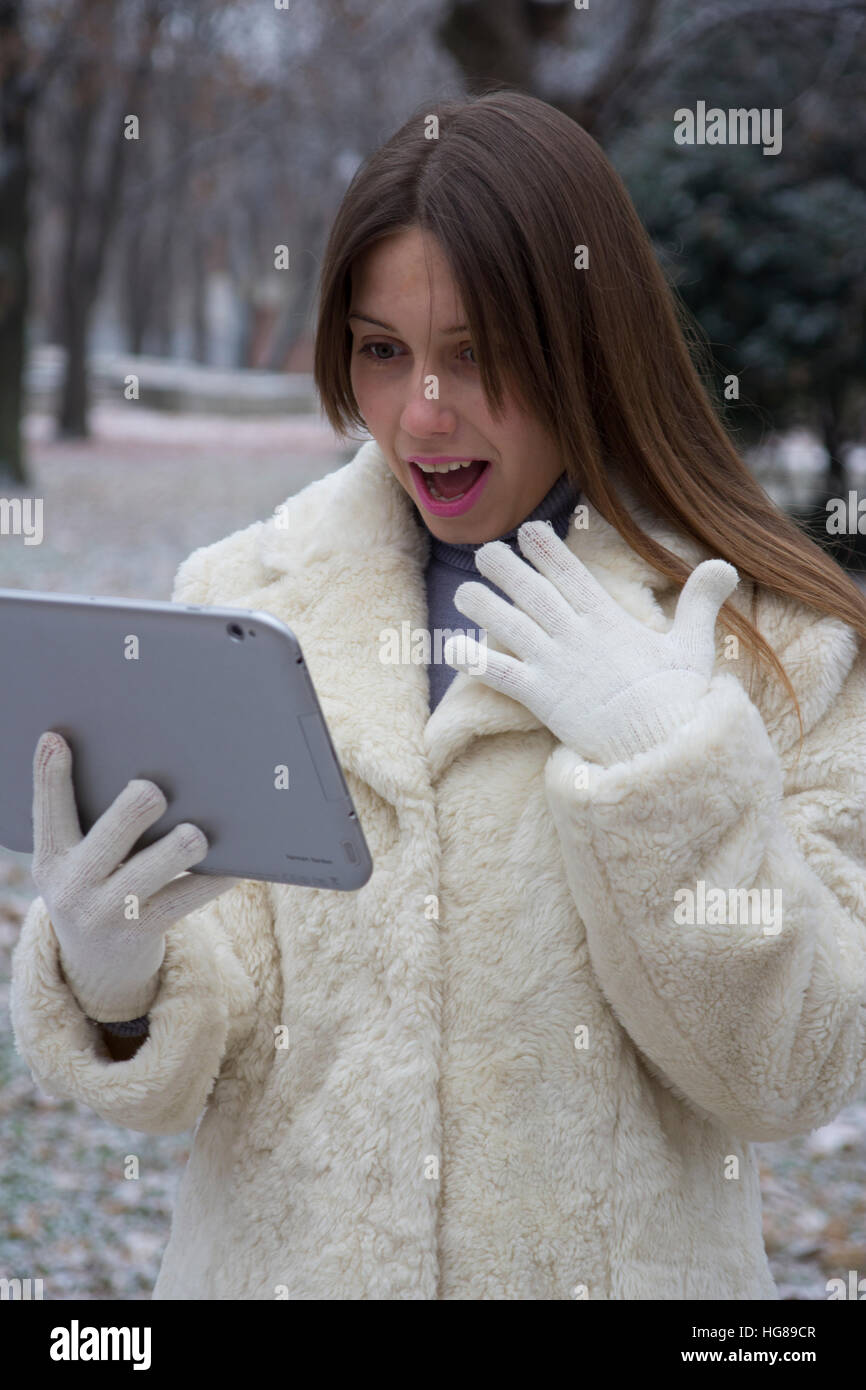 young girl in the park looking at tablet Stock Photo - Alamy