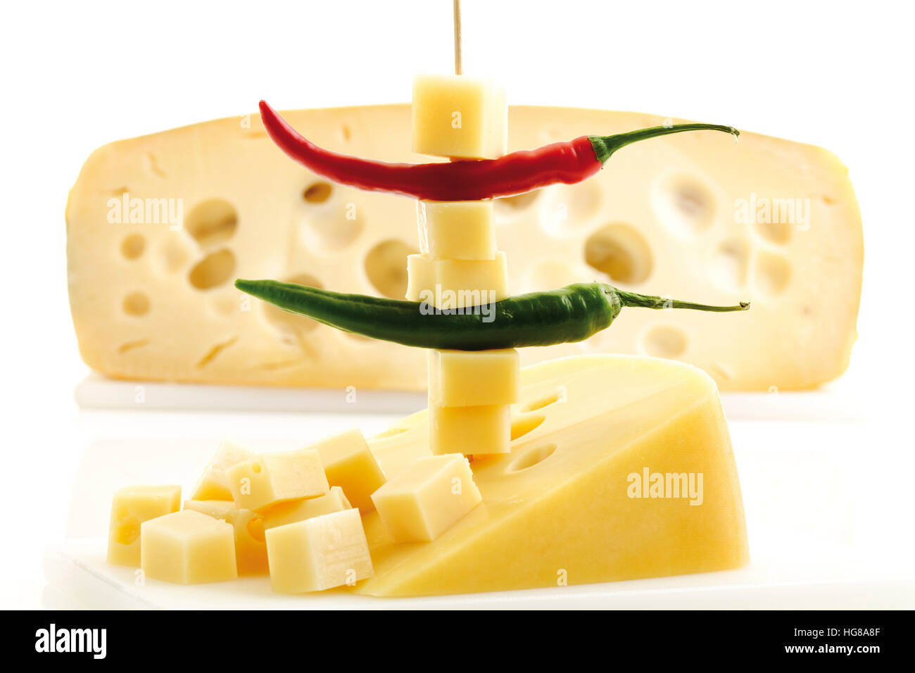 Diced cheese and hot peppers on a toothpick, half a cheese wheel in