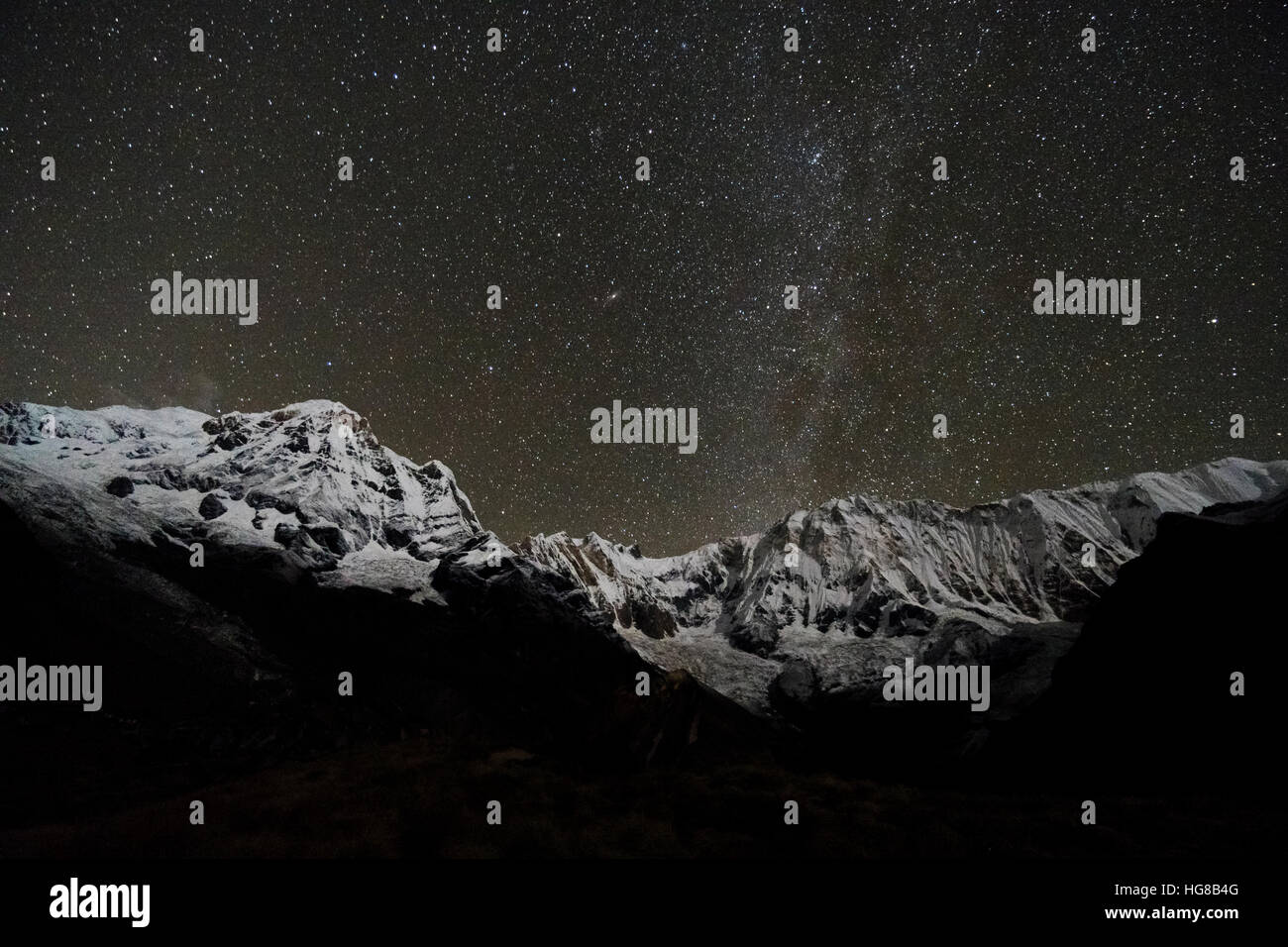 View of the snow covered Annapurna 1 North Face, mid, and the Annapurna  South summit , left at night with stars and Milky Way Stock Photo - Alamy