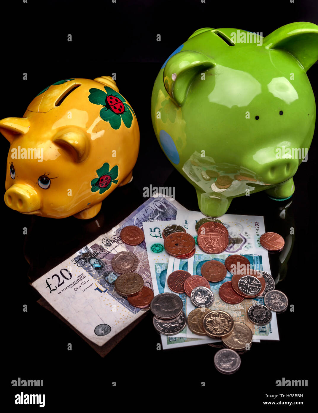 2 piggy banks notes and coins Stock Photo Alamy