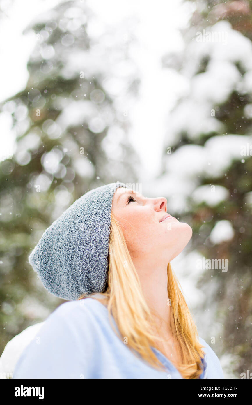 Woman looking up during snowing Stock Photo