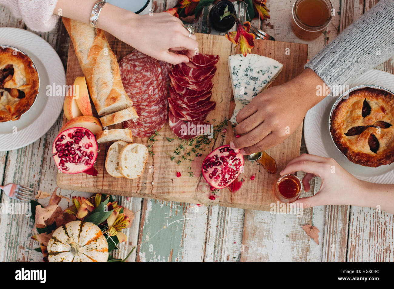 Overhead view of hands taking food on table Stock Photo