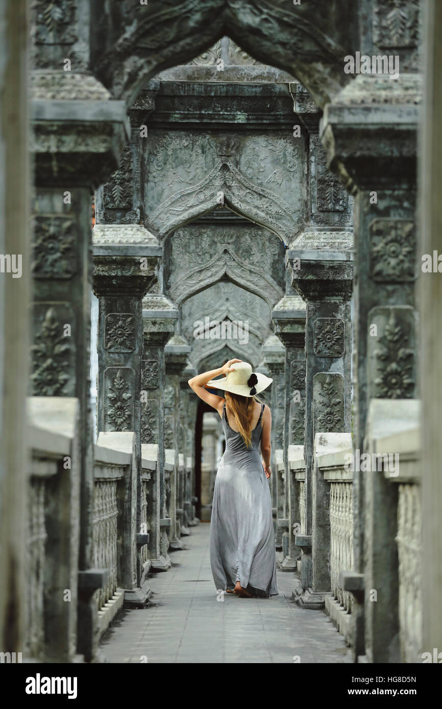 Rear view of woman in dress while walking on bridge at Karangasem water temple Stock Photo