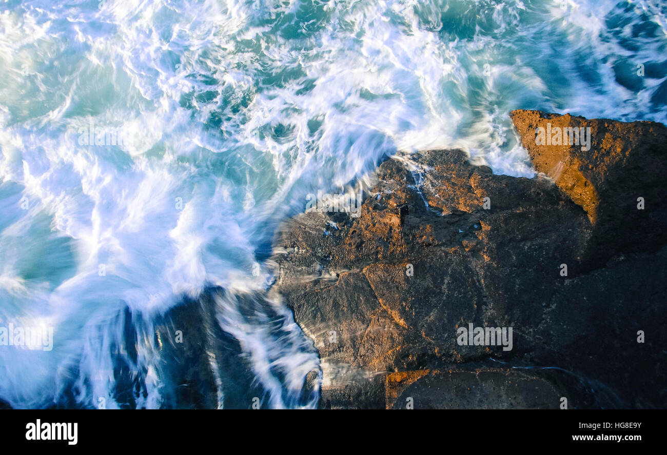 High angle view of waves splashing on rocks in sea Stock Photo - Alamy