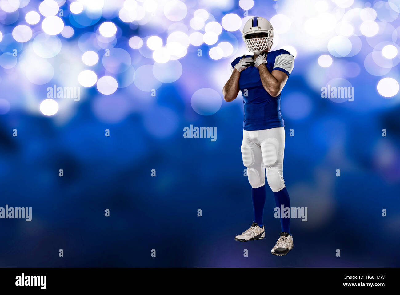 Football Player with a blue uniform on a blue lights background Stock