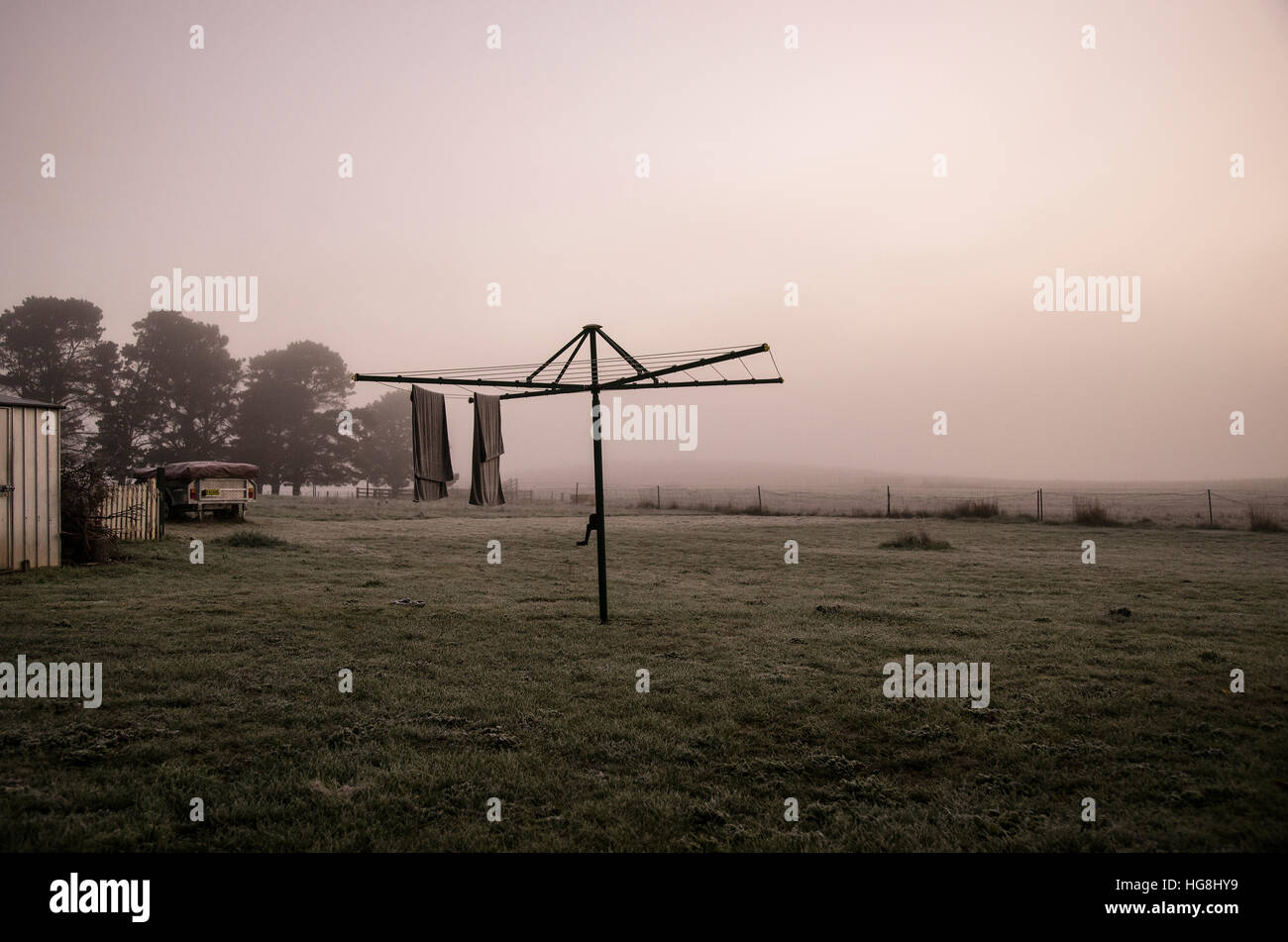 towels hang from a clothesline in foggy mist in dawn Stock Photo