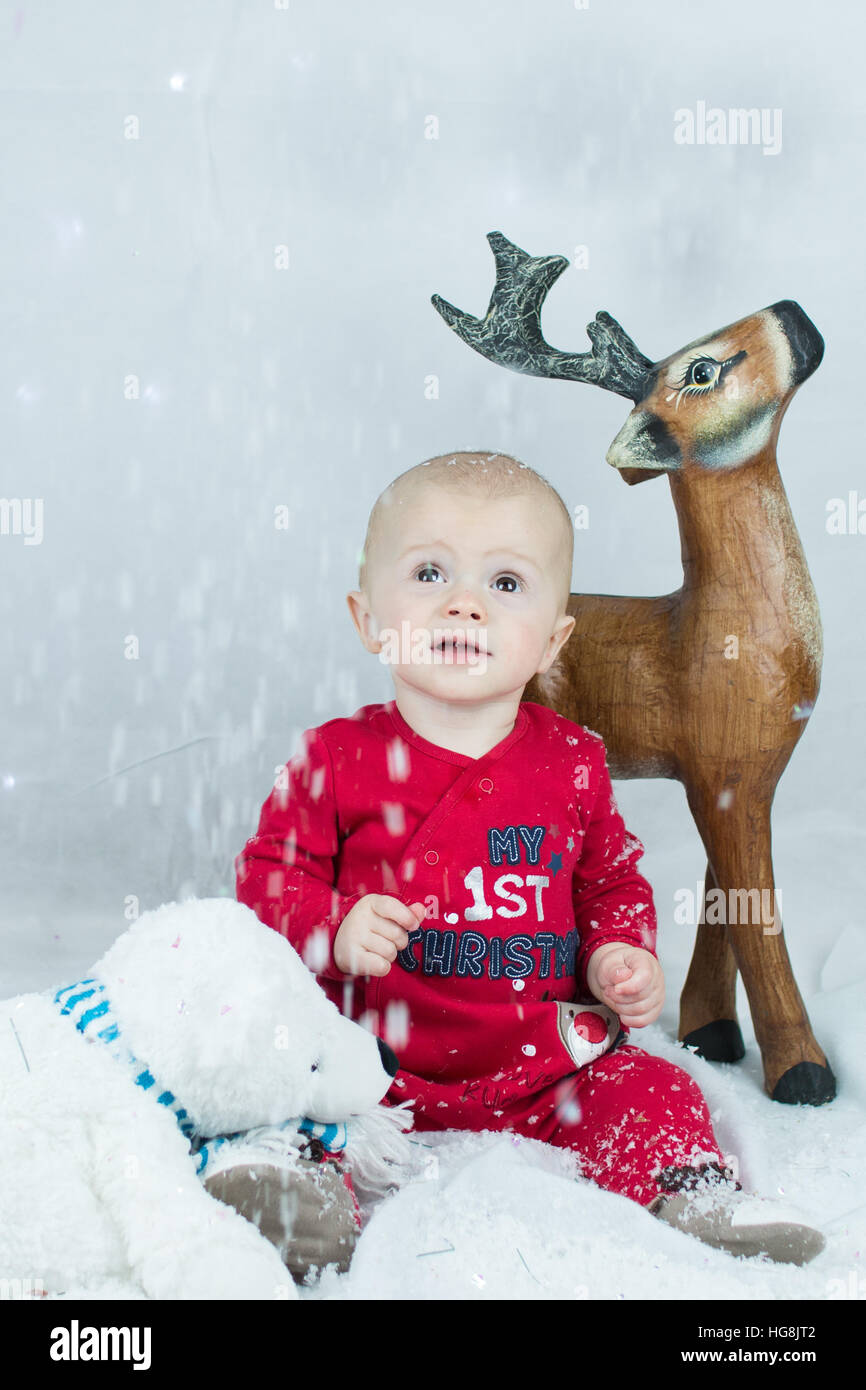 baby first Christmas in the snow with toys Stock Photo