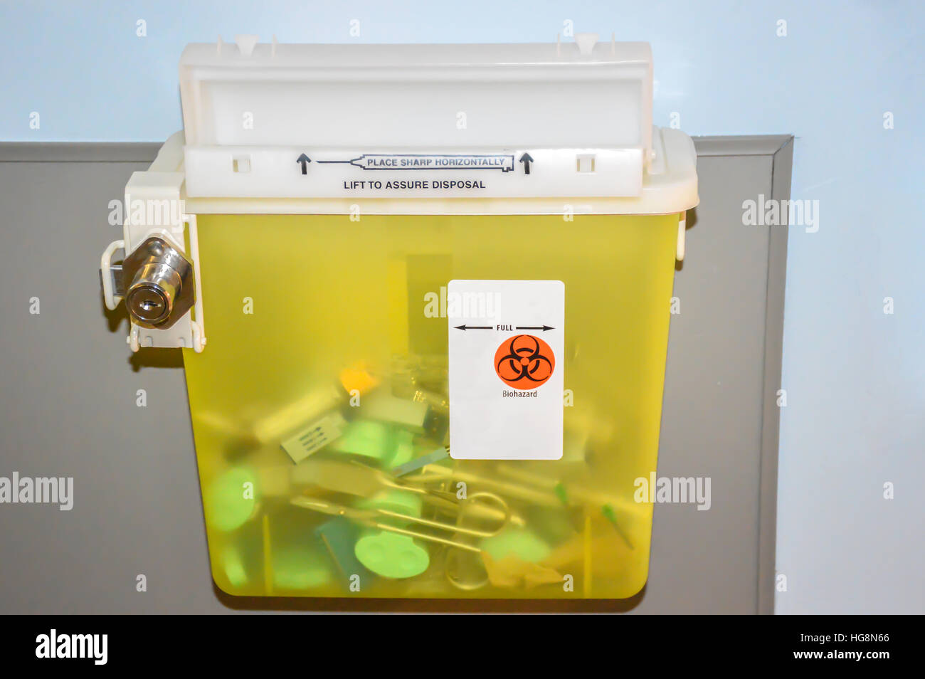 Photo of a locked yellow sharps container with used syringes, needles