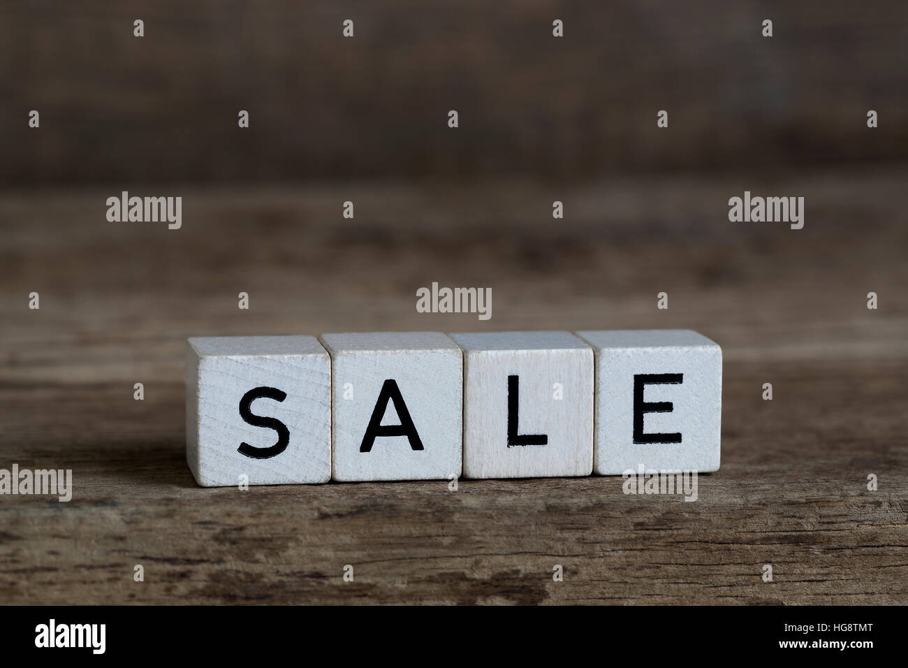 Sale, written in cubes on wooden background Stock Photo