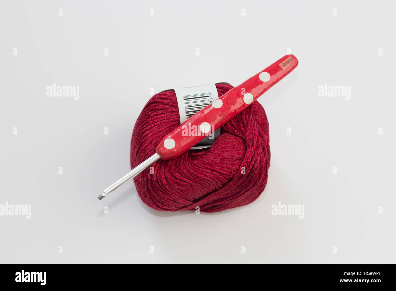 Red ball of wool with red novelty crochet hook on white background Stock Photo
