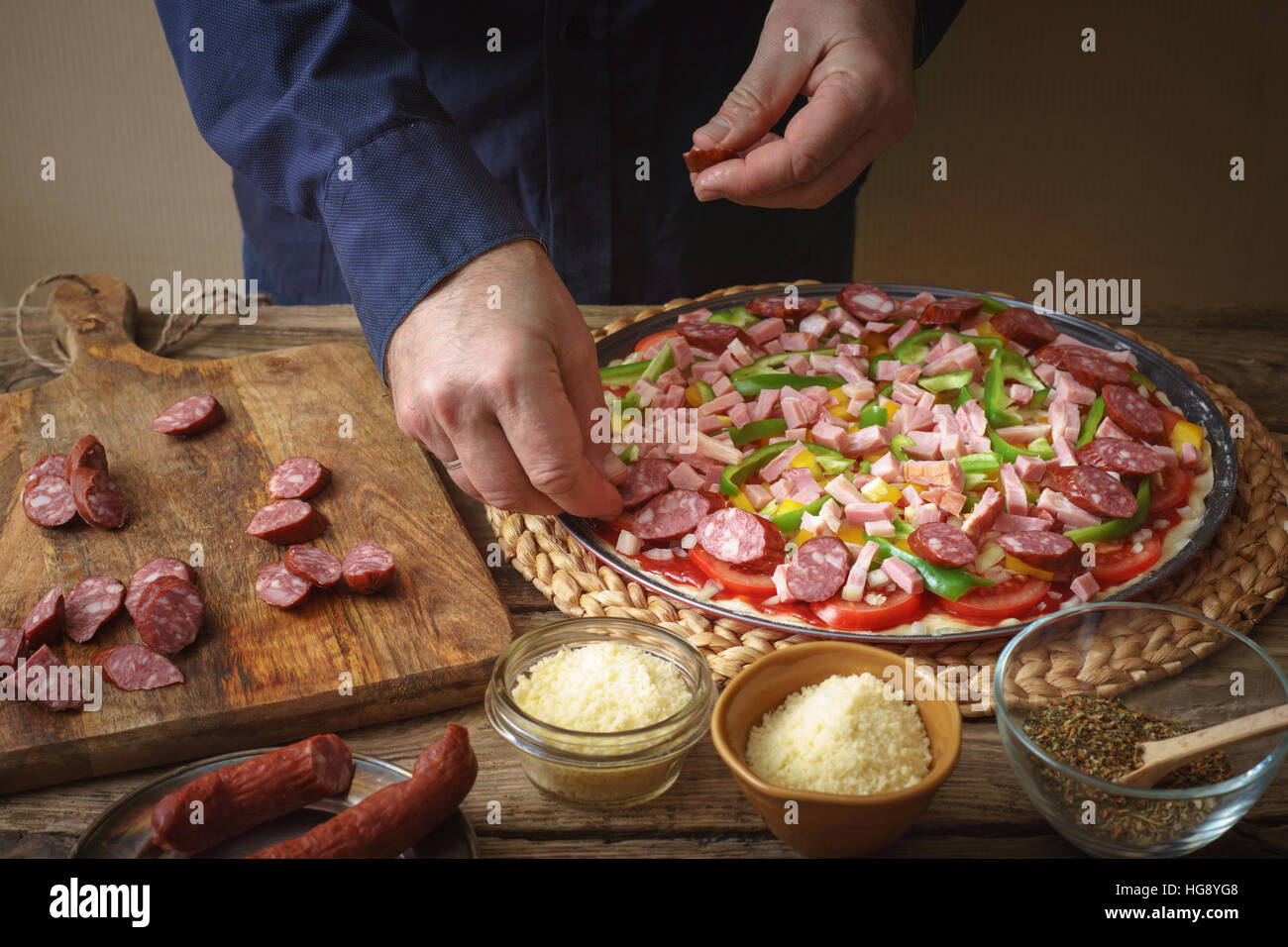 Man in a blue shirt makes homemade pizza on the table horizontal Stock Photo