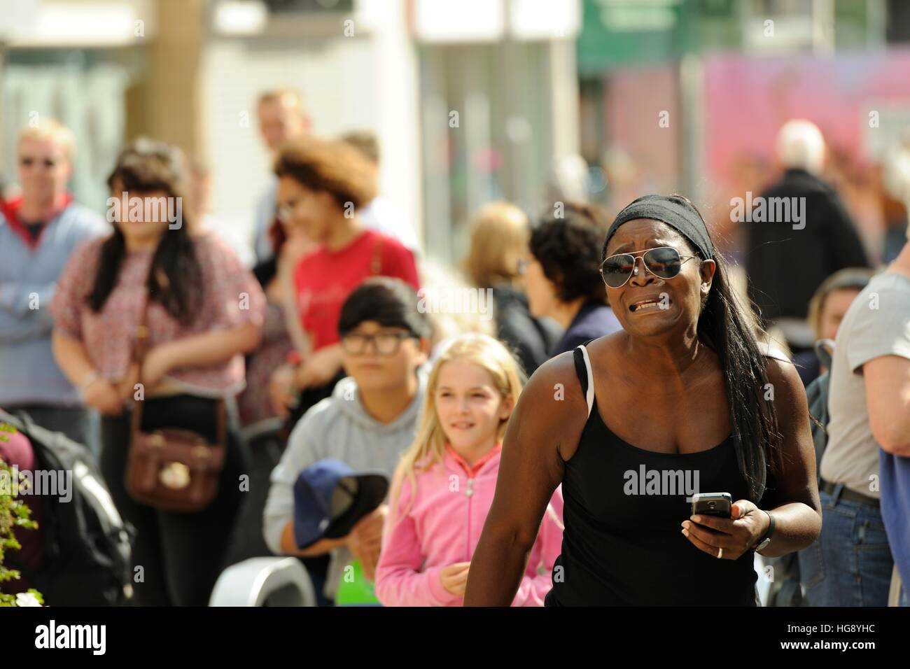 Afro-Caribbean woman and blond girl watching musicians on the Moor Sheffield, taking part in the Tramlines Festival Fringe 2014 Stock Photo