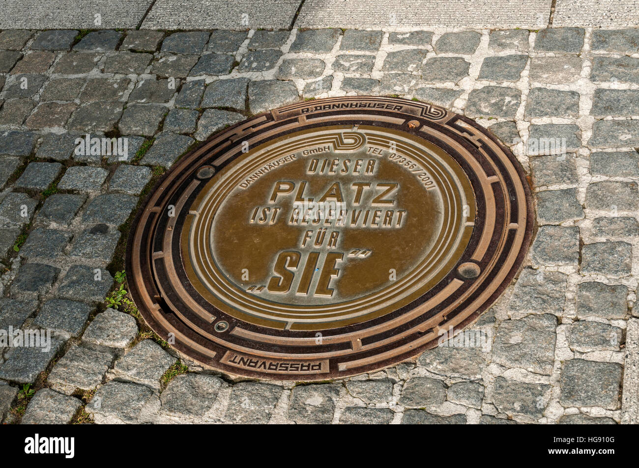 Man-hole cover with self promotion, Germany. Stock Photo