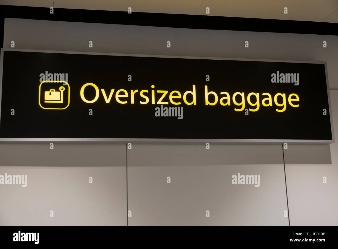 Oversized large over sized passenger luggage bag drop baggage dropping off point sign check in aircraft hold. Gatwick Airport UK Stock Photo