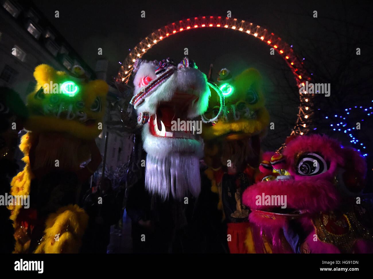 People dance in Chinese Dragon costumes during the launch of London's Chinese 2017 New Year celebrations at the London Eye. Stock Photo