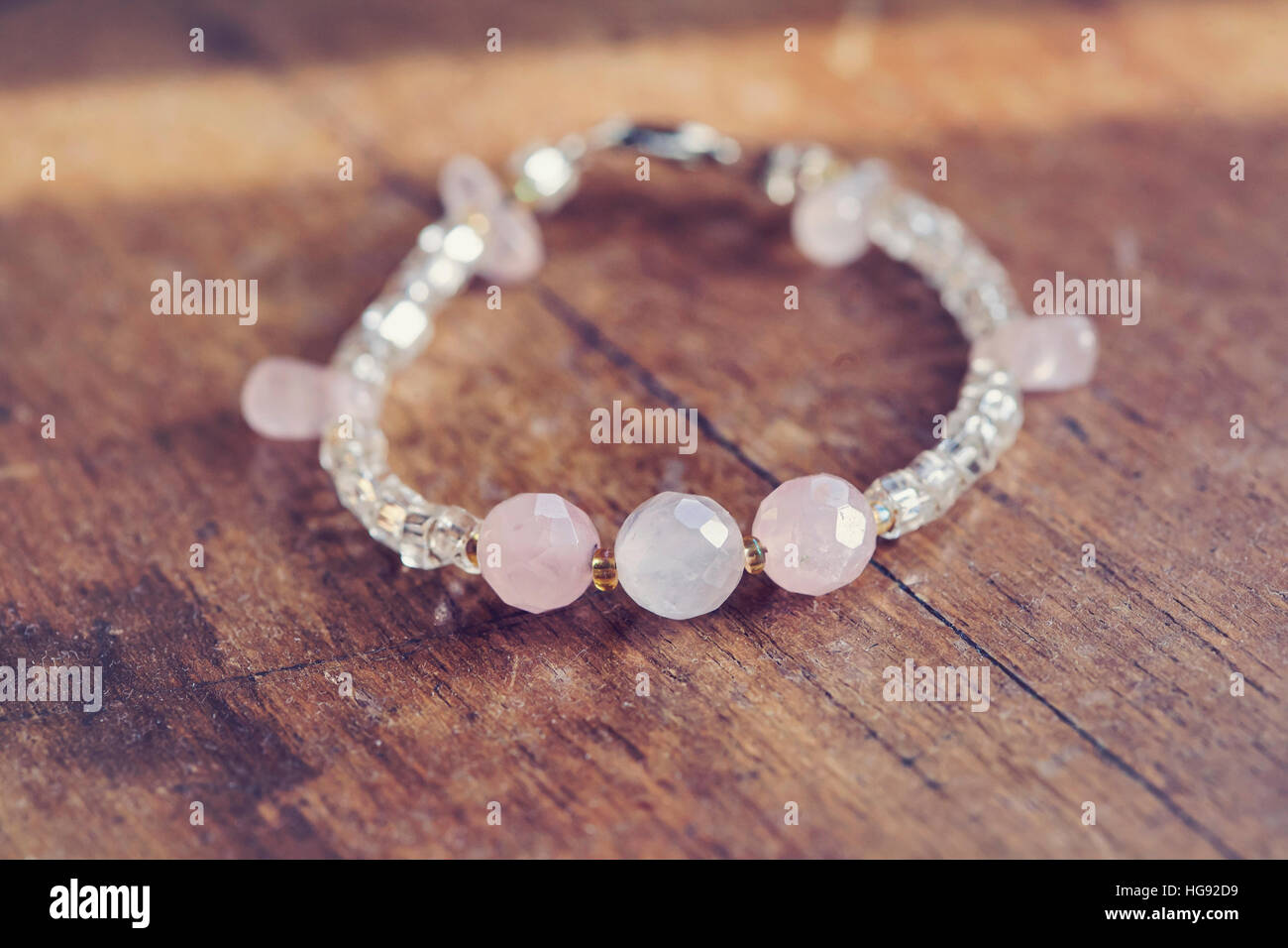 Beautiful rose quartz bracelet on wooden table Stock Photo