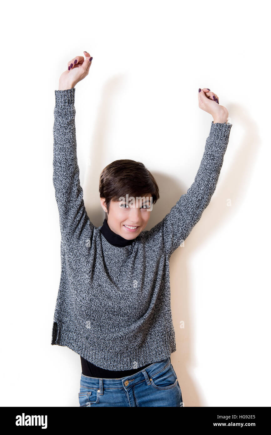 Young brunette woman arms up, expression of victory, success, bliss, happiness, winning, isolated on white background Stock Photo