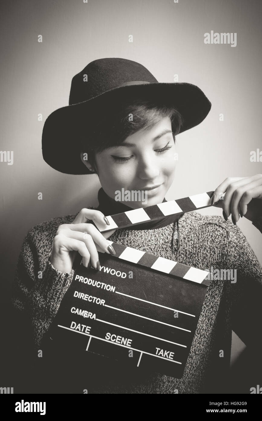 Young woman portrait, actress smiling and holding movie clapper, vintage black and white Stock Photo