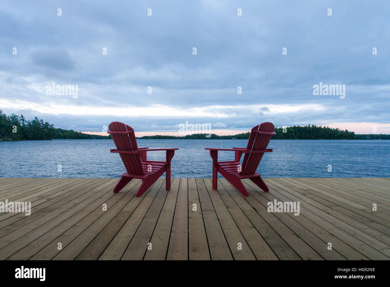 Classic Muskoka, also known as Adirondack Chair(s) sit on a wooden dock