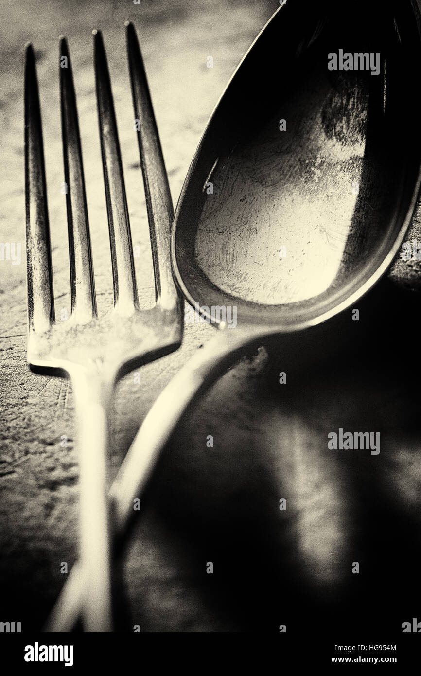 Antique fork and spoon photographed close up with shallow focus. Sepia toned fine art wall decor Stock Photo