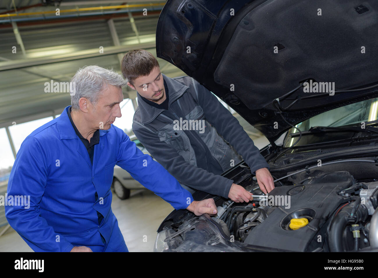 two professional car mechanics checking up engine Stock Photo Alamy