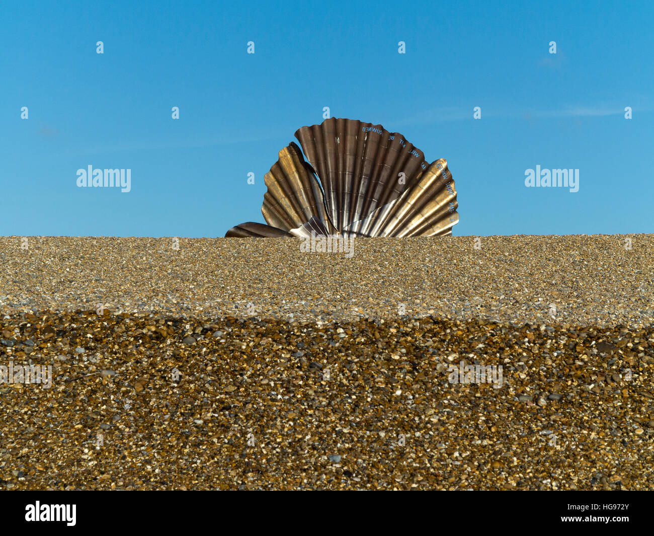 'The Scallop' stainless steel sculpture by Maggi Hambling on the shingle beach at Aldeburgh Suffolk England against a blue sky Stock Photo