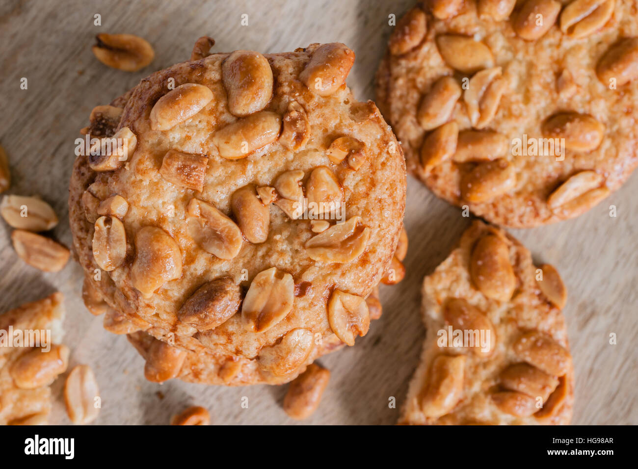 Salted crunchy peanut cookies freshly baked with crumbs and pieces on a wooden plate top down view Stock Photo