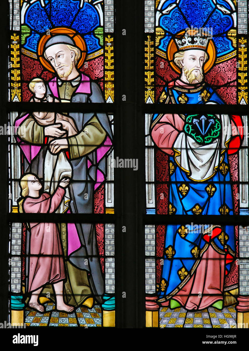 Stained Glass window depicting Saint Vincent de Paul and Saint King Louis IX of France in the Cathedral of Saint Bavo in Ghent, Belgium. Stock Photo