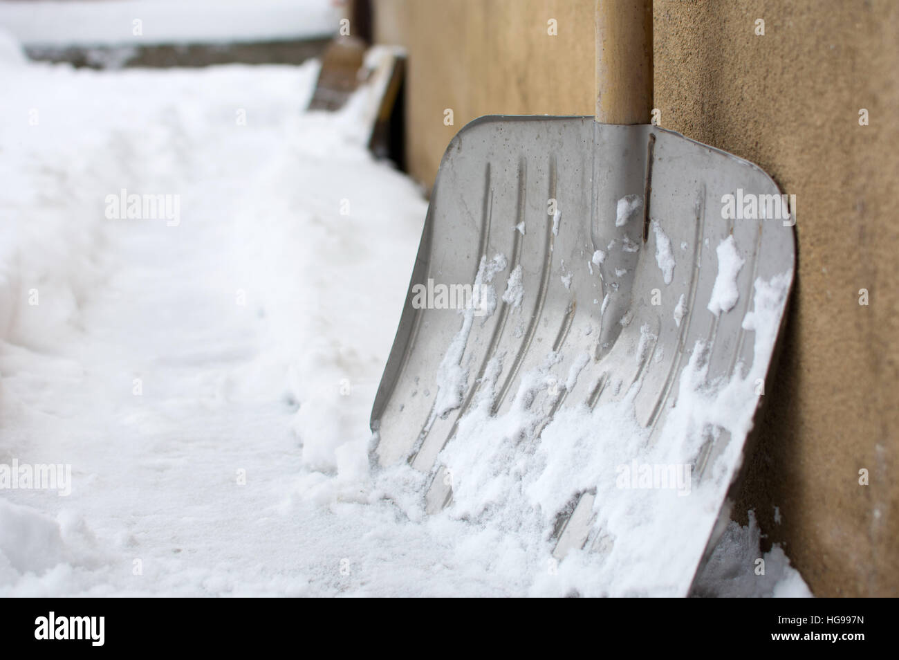 Snow shovel in a snowed front yard Stock Photo