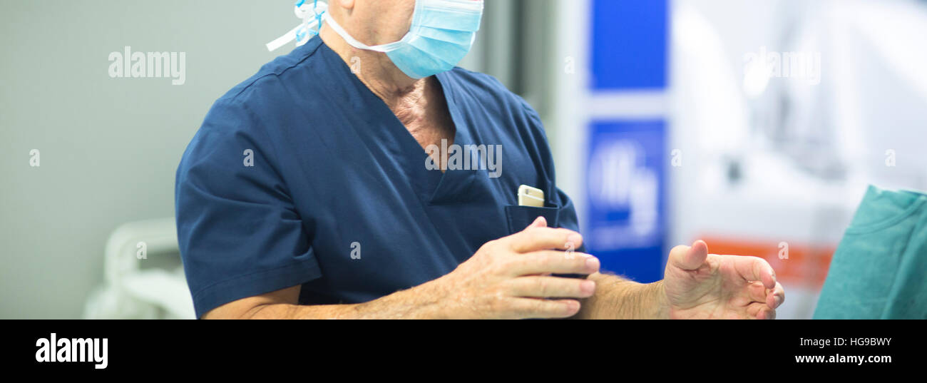 Surgeon in hospital surgery in sterile uniform "scrubs" with washed