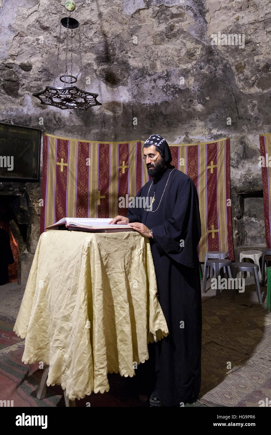 Jerusalem, Israel - December 26, 2010: Syrian Orthodox priest  holds Sunday mass in the Syrian Chapel next to Saint Joseph of Eritrea tomb in the Chur Stock Photo