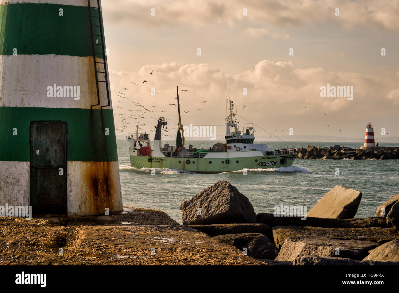 Fishing boat entering harbour Stock Photo - Alamy