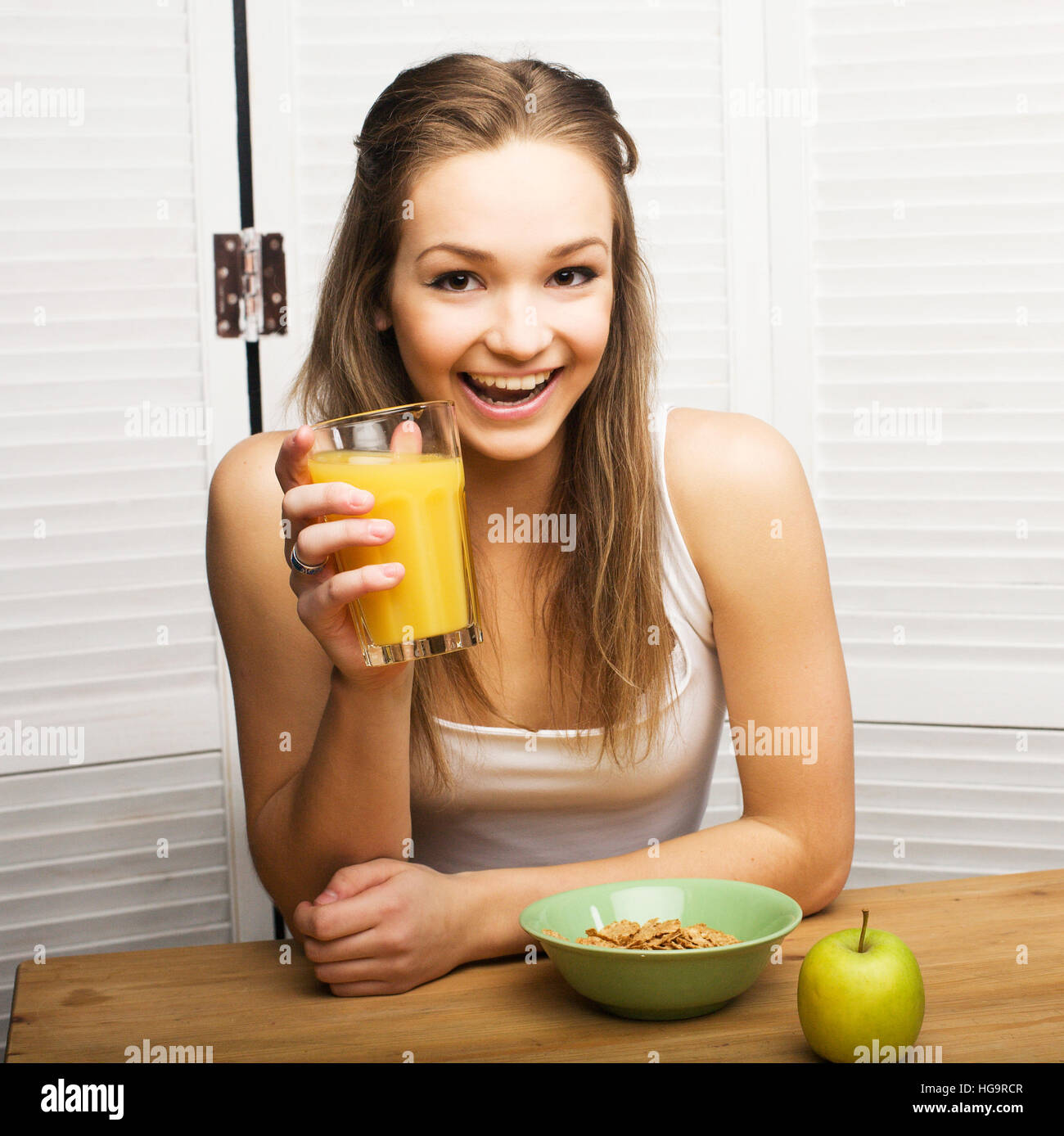 portrait of happy cute girl with breakfast, green apple and orange