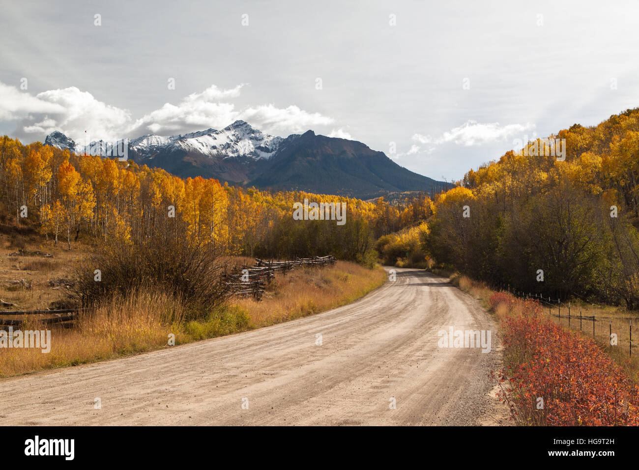 A country road winds into the Colorado mountains near the Dallas Divide on an autumn day. Stock Photo