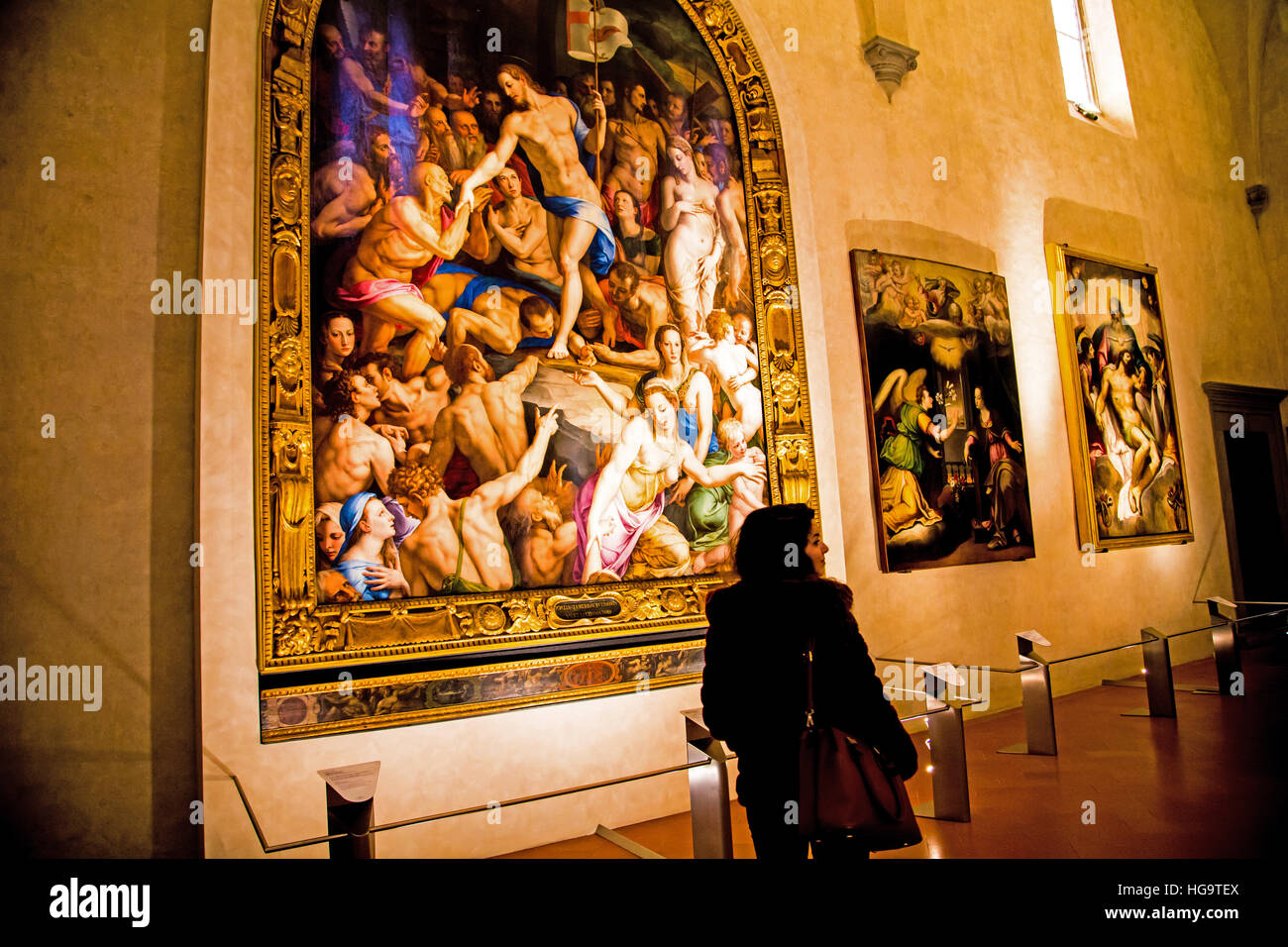 Woman standing by "The Descent of Christ into Limbo" by Bronzino in Santa Croce Basilica in Florence Italy Stock Photo