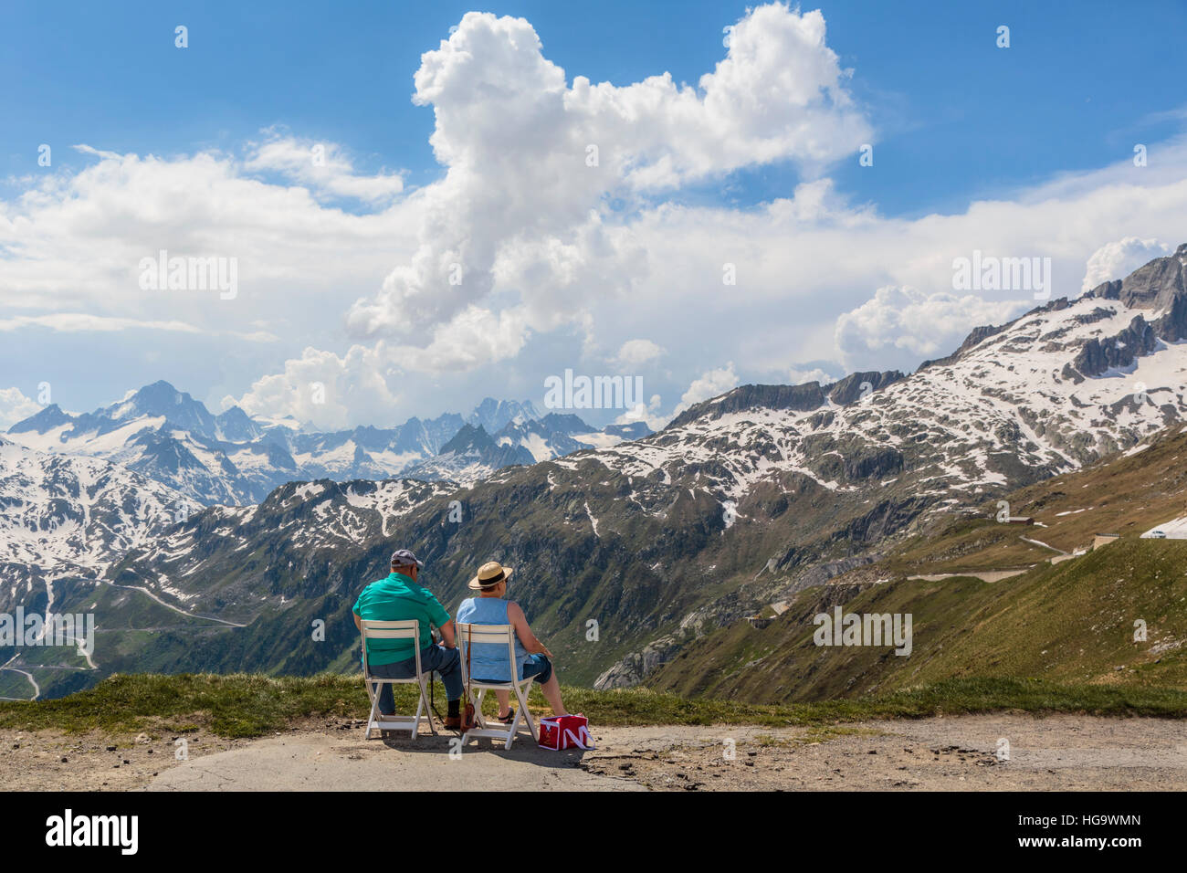 Third age couple admiring view in the Furka Pass, Swiss Alps, Valais Canton, Switzerland. Stock Photo
