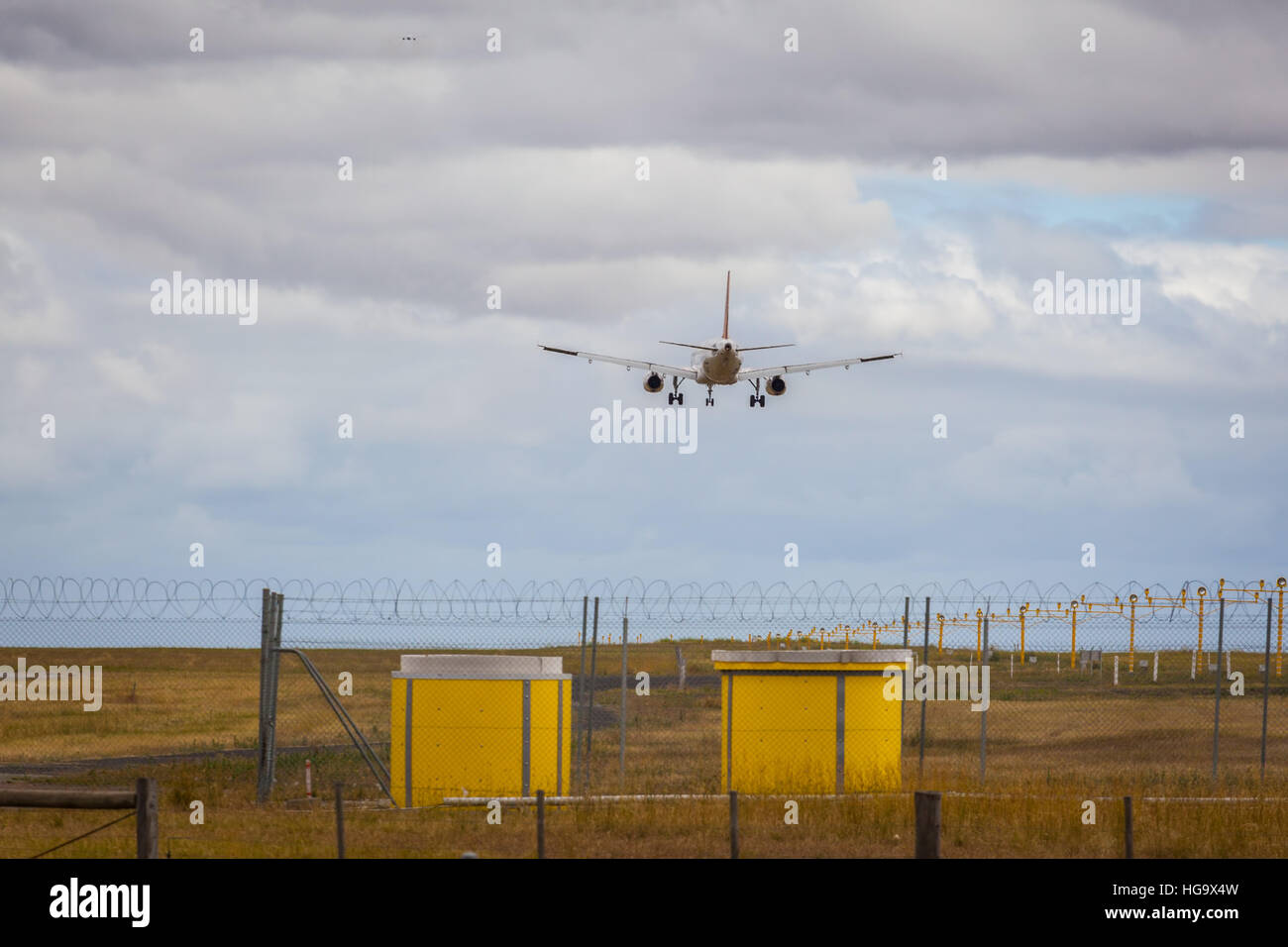 Passenger jet airplane landing at airport Stock Photo