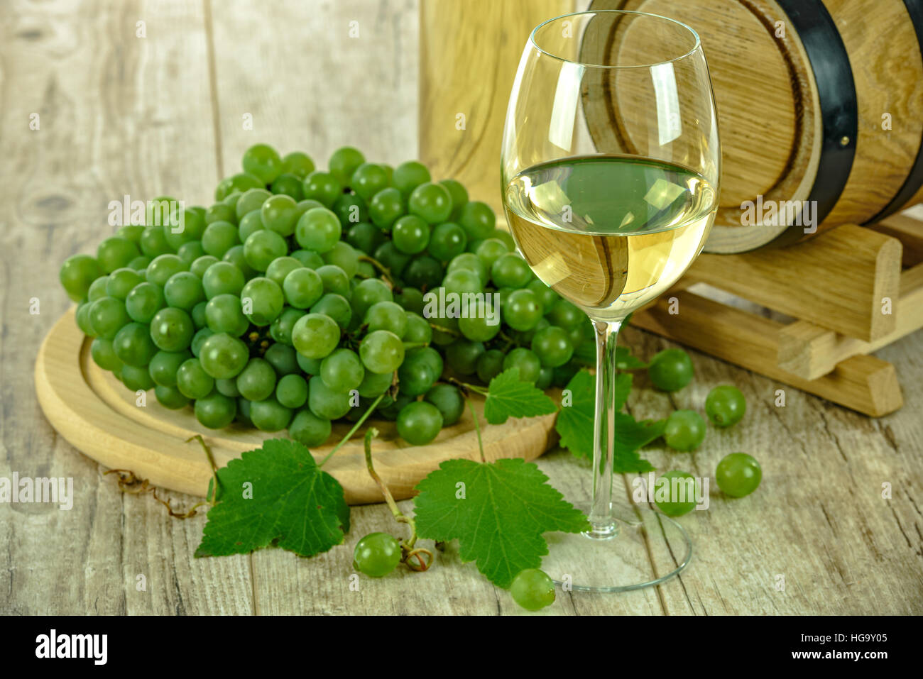 Semi sweet white wine in the cup next to fresh grapes and a wooden barrel Stock Photo Alamy